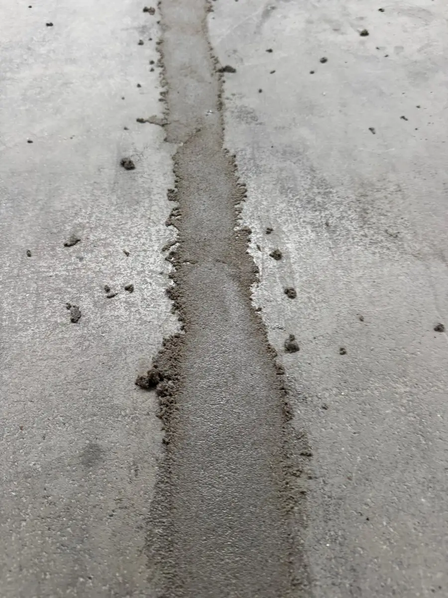 Dilatatievoeg in een betonvloer die wordt uitgefreesd en opgevuld tijdens het herstel