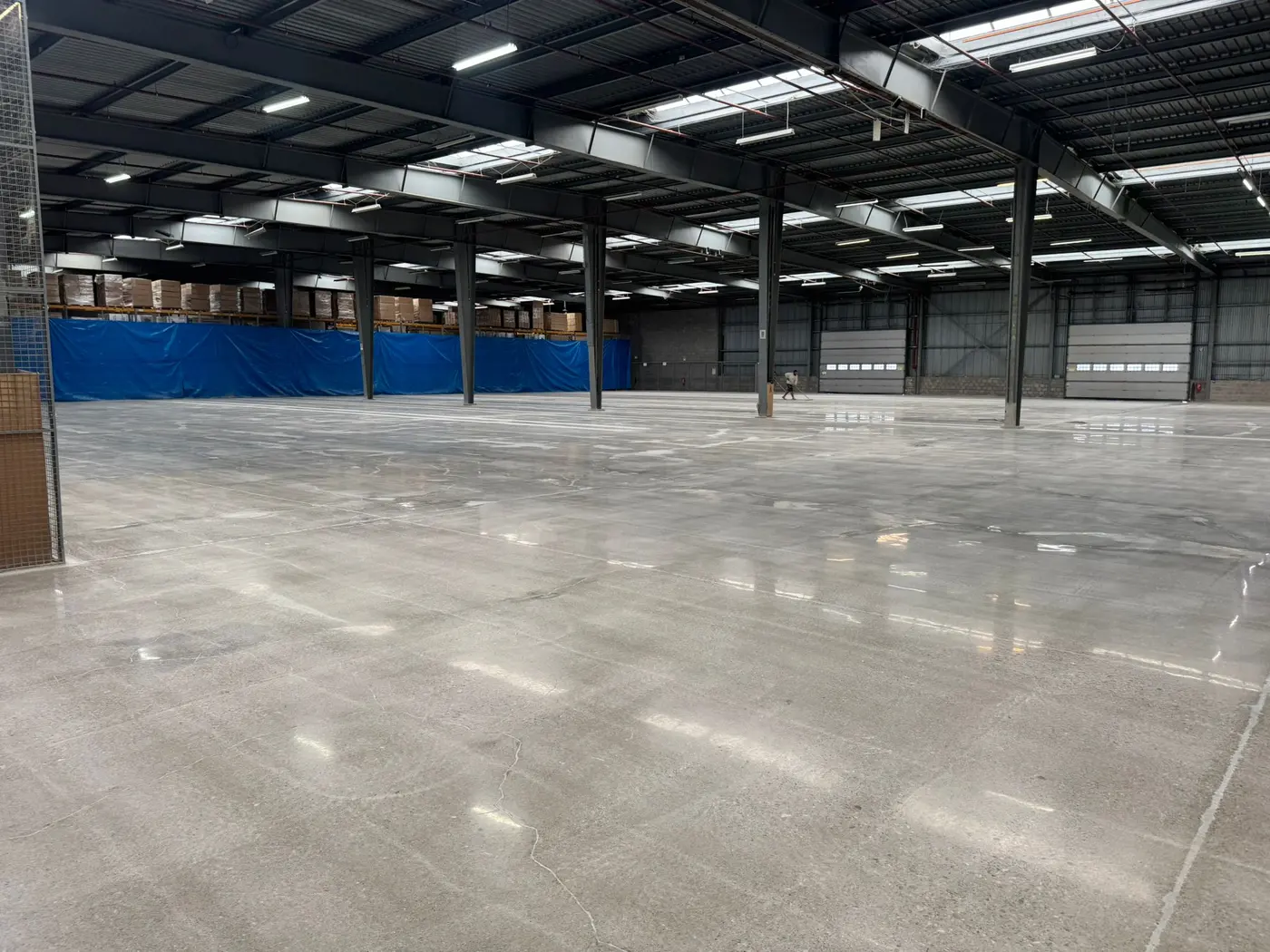 Realisatie: gepolijste betonvloer in het magazijn van Merle Vastgoed met zichtbare lichtreflectie