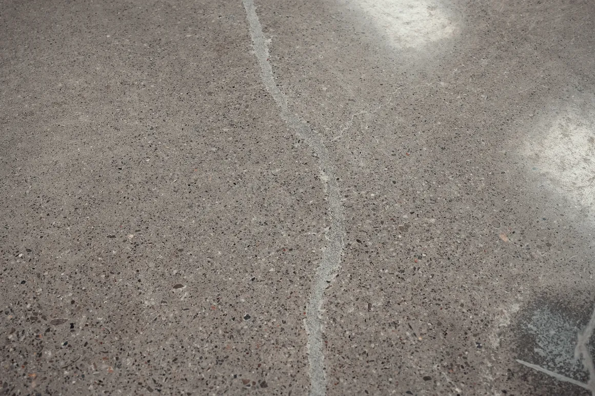 Close-up van een gedichte scheur in de geschuurde en gepolijste betonvloer