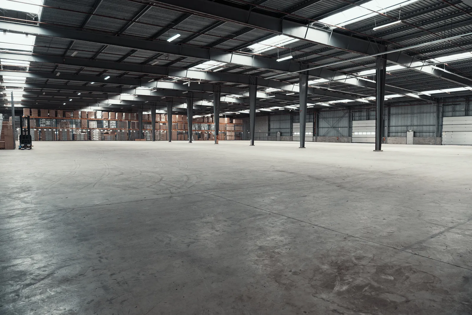 Doffe, versleten betonvloer in het magazijn voor de renovatie